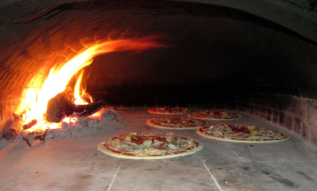 Verse pizza's aan het bakken in de bakoven